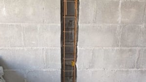 Échelle de chantier entre deux murs bétonnés