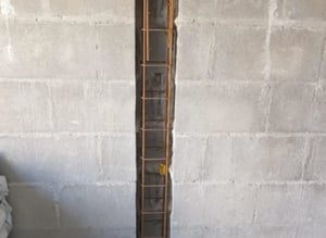 Échelle de chantier entre deux murs bétonnés