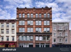 stock-photo-street-with-facades-of-old-fashioned-apartment-buildings-2276496751